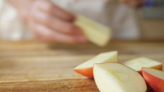 手在木制砧板上切苹果