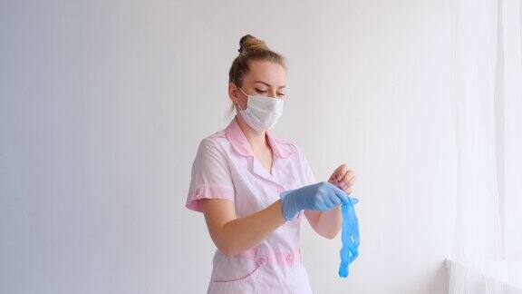 医生或医护人员穿着粉红色的制服戴着防护口罩戴着手套保持社交距离隔离冠状病毒