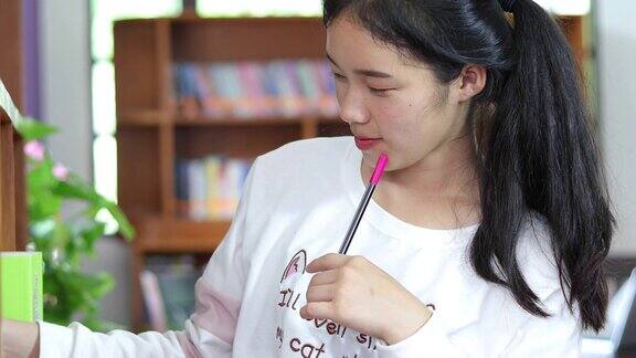 亚洲女学生在图书馆借书