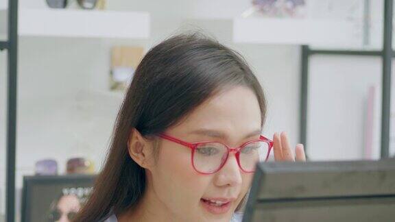 一个年轻女人的肖像戴着眼镜和微笑在一家眼镜店快乐