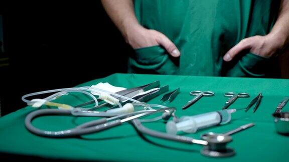 4K医疗摄像机放置在覆盖着绿色布的桌子上为患者清洁手术在背景中医生站在检查设备为手术做好准备手术期间不会丢失