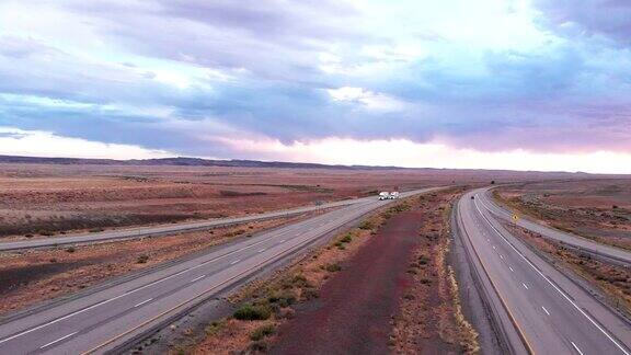 在荒凉的沙漠中在四车道高速公路上在黄昏或黎明行驶的长途货运拖车