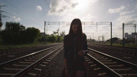 一个年轻女子在铁路上走了摇滚风格