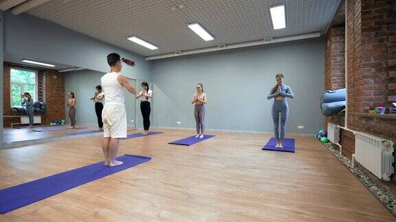 专业教练为年轻女性进行瑜伽训练