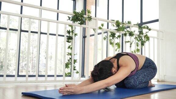 女性瑜伽冥想伸展背部手臂冥想居家健身地板年轻女性在做瑜伽时摆出幼儿姿势健康女性在运动装冥想放松拉伸保健