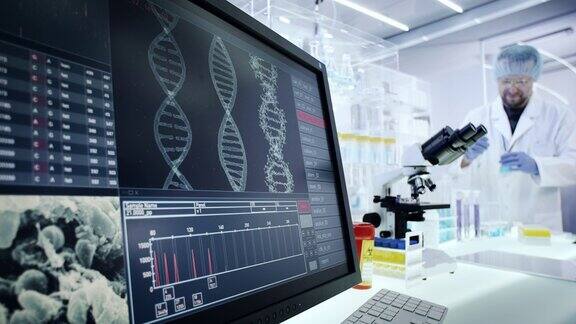 在实验室设备上工作的人电脑屏幕上的DNA研究