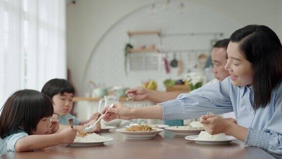 亚洲家庭在厨房内的餐桌上吃早餐家庭关系密切