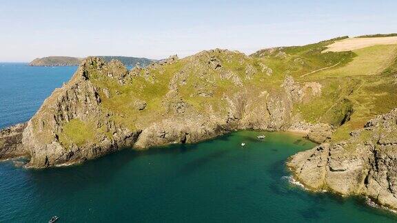 岩石海岸悬崖和小海湾渔船美丽的英国海岸线