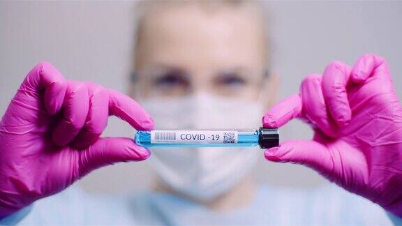 在实验室工作科学家在实验室拿着COVID-19冠状病毒检测阳性的试管