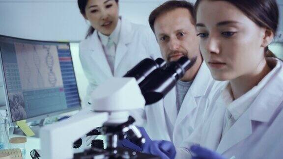 多民族实验室团队处理病原体样本女医生使用显微镜