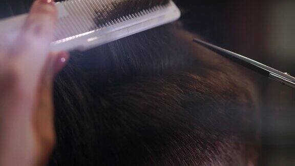 近距离的男人理发剪在美容院框架在美发沙龙理发的特写专业理发师为他的客户设计发型