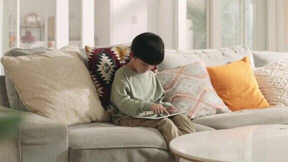 亚洲小男孩在家使用数码平板电脑