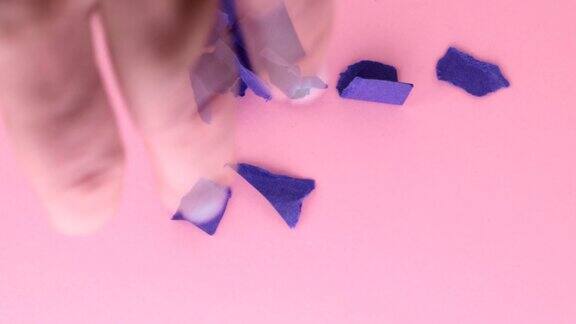 4k视频一个女人的手从桌子上取下粉底紫色的皱褶纸俯视图