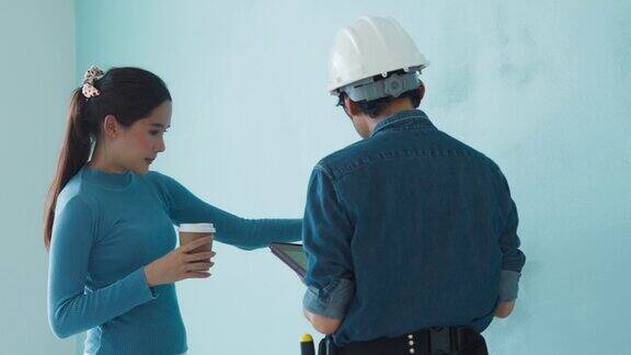 亚洲年轻女建筑师与日本男性建筑经理承包商讨论质量控制现场检查和房屋施工现场装修工程