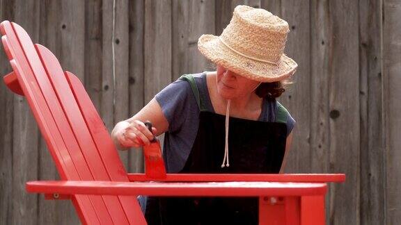 一个成熟的女人在后院等着一把沙滩椅