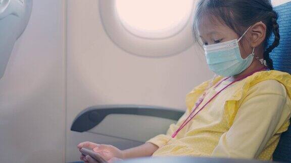 亚洲小女孩喜欢带着口罩在飞机上使用手机