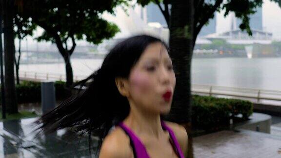 一名中年亚洲妇女在新加坡雨中慢跑