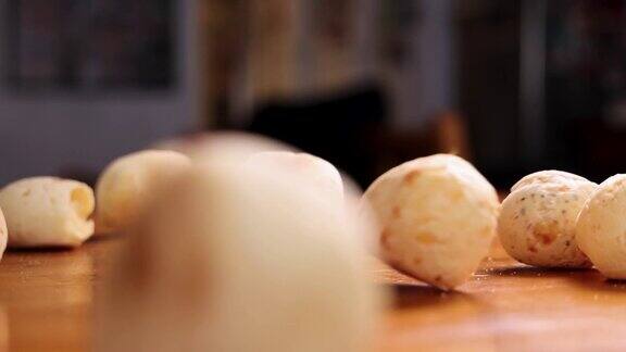 巴西奶酪面包球被扔在木桌上的慢动作