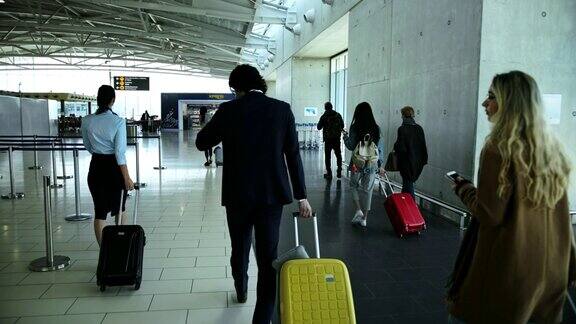 多民族旅客走在机场走廊上向登机口走去
