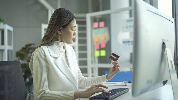 女商人手里拿着信用卡用电脑在网上购物
