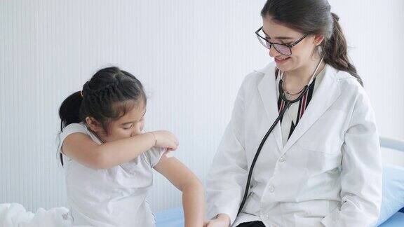 接种完疫苗后小女孩展示了她手臂上的绷带