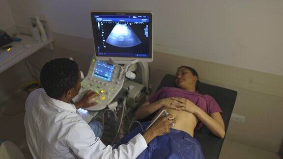 女性患者在医院接受超声波检查男性医生一边看图像一边解释