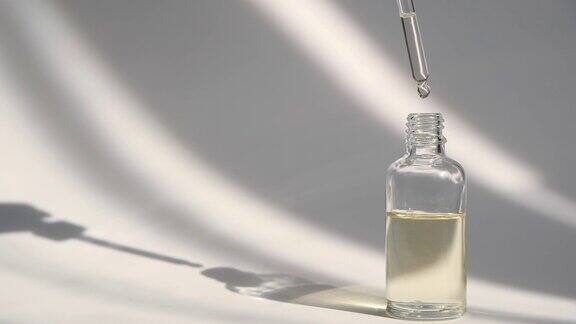 滴管玻璃瓶模型化妆品吸液器上的油滴落在白色背景上石油泡沫