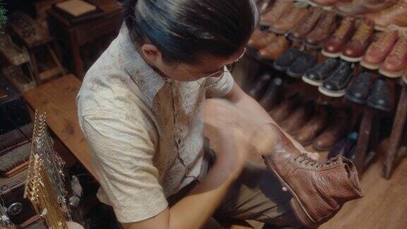 男鞋匠在修复车间抛光旧皮鞋