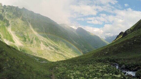 高加索山脉美丽的山谷草地与彩虹