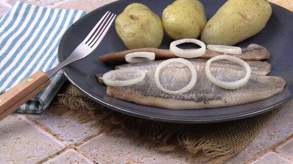 油鲱鱼片和土豆放在盘子里