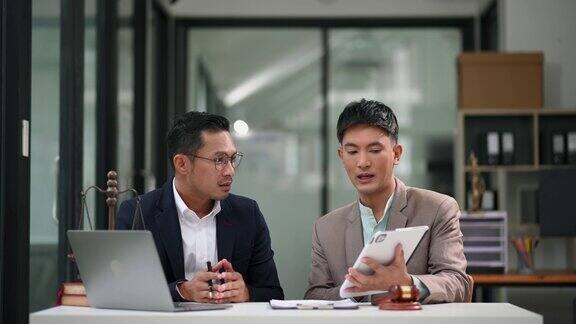 亚洲商业团队和律师坐在桌边讨论合同文件法律建议法律服务在现代办公室