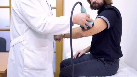 医生对病人的肘部做超声波检查
