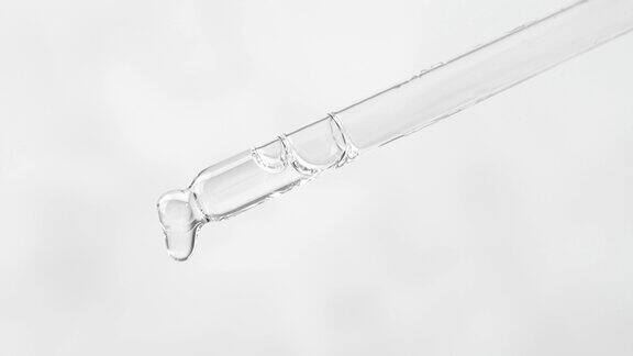 特写玻璃滴管与化妆品液体在一个普通的背景精油身体精华液滴滴