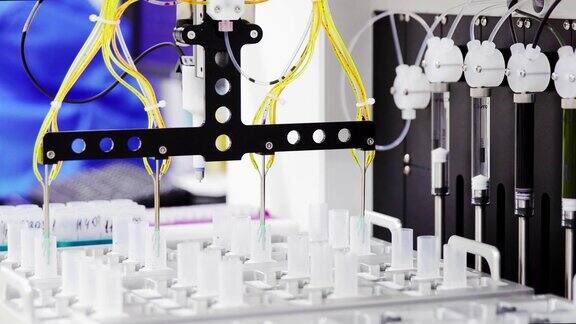 实验室机器人的特写镜头将用于分析的药物催化剂注射到试管中
