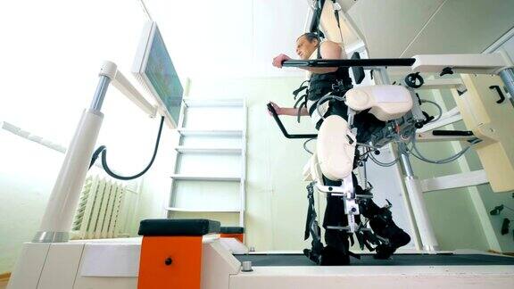 医疗机器人医疗训练室一名男性病人在步行模拟器上锻炼