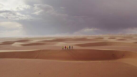 五名徒步旅行者站在沙丘上