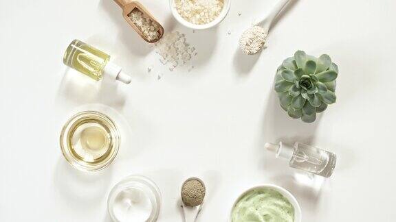 环保产品白色背景与绿色芦荟凝胶、液体、胶原蛋白精华、精油、盐、按摩刷天然有机护肤生态化妆品平的