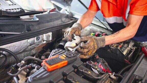 在车库里修理汽车发动机的专业机械师