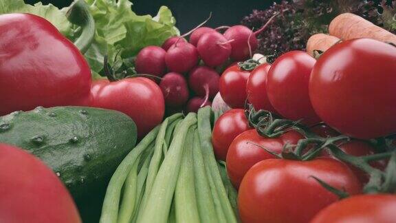 新鲜有机湿蔬菜滑动镜头健康的夏季蔬菜收获在黑色背景番茄、黄瓜、辣椒、大蒜、萝卜、欧芹和生菜