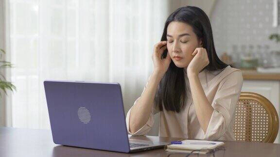 亚洲女性在使用电脑工作后感到疲惫医疗保健