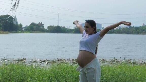 孕妇在湖边放松手臂伸展