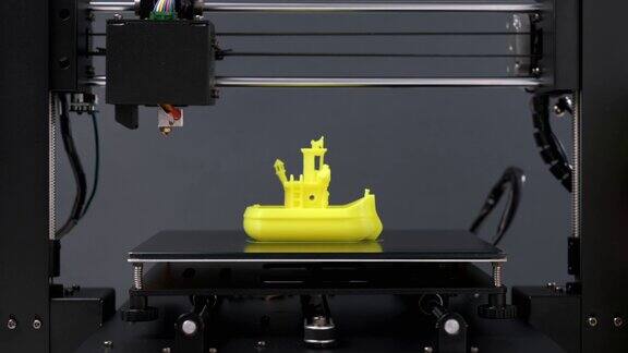 打印3D打印机雕像玩具船从黄色塑料特写打印头和打印机工作台运动清晰现代技术3D打印的潜力塑料盘