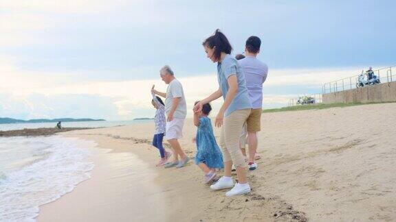 亚洲大家庭在沙滩上冲浪