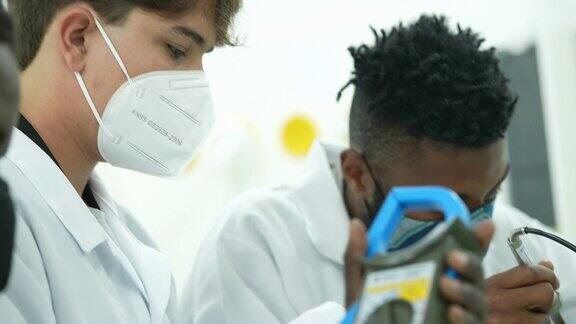 年轻男子在实验室里研究电子设备戴着口罩