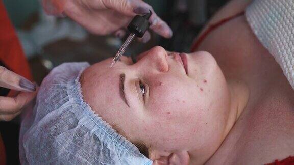 美容师用吸管将液体涂抹在女人脸上