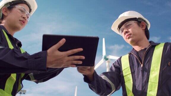 两名技术人员在风力发电场一起检查风力发电机环保为未来的清洁能源