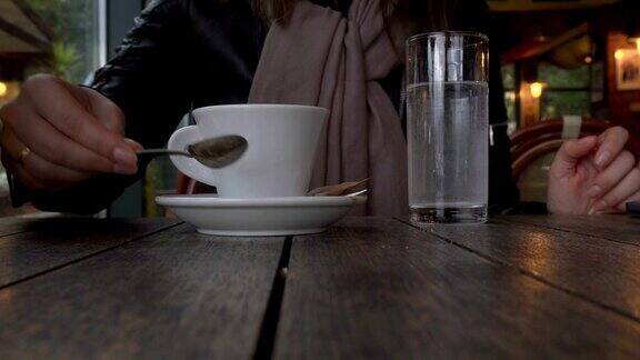 一个女孩坐在咖啡馆里喝咖啡特写镜头