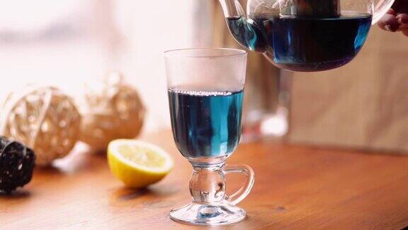 蓝蝴蝶豌豆茶从花阴蒂里亚在咖啡馆的桌上泰国花蓝色茶倒入一个透明的杯子茶减肥健康排毒