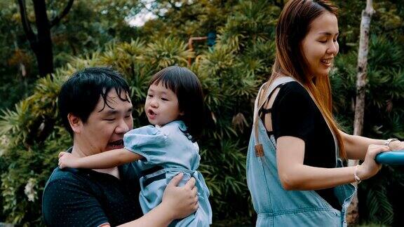 一个亚洲家庭和一个小女孩在公园里享受