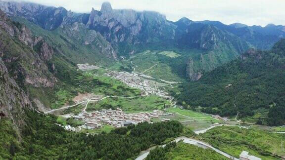 无人机拍摄的山谷、绿色草地和民居中国甘南州洛克路